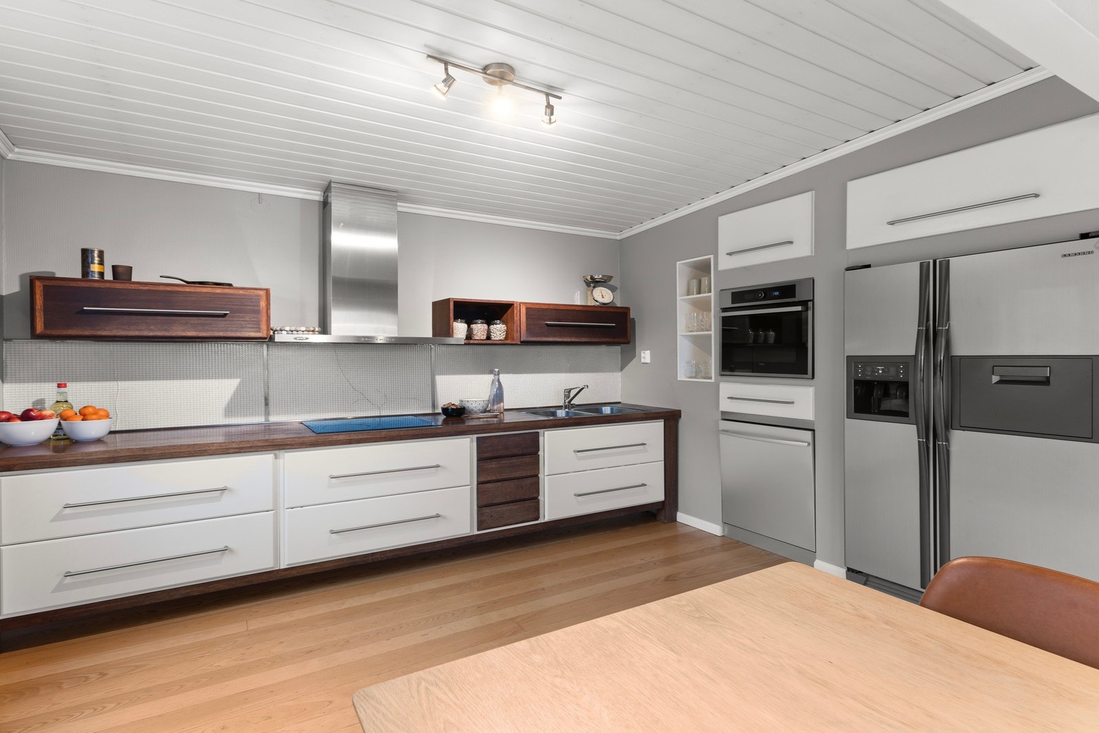 Delvis åpent mot stua med pen, skandinavisk innredning, plassbygde detaljer og integrerte hvitevarer. Galleribilde