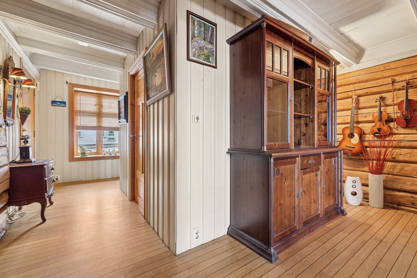 Gangen er gjennomført i en kombinasjon med parkett på gulv, samt vegger kledd i delvis panel og av opprinnelig tømmer. Galleribilde