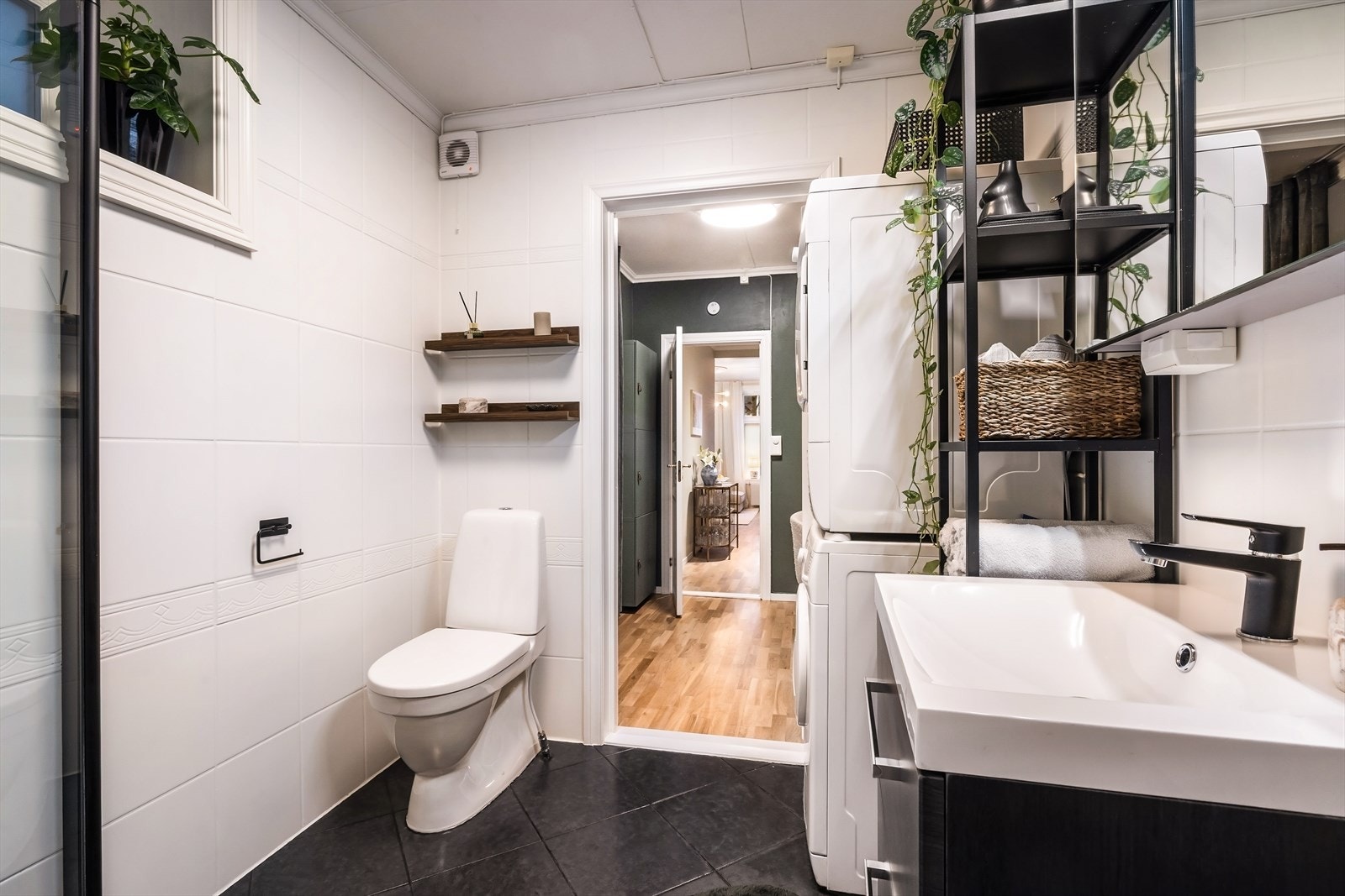 Badet har blitt innredet med wc, servant med møblement, speil, belysning og dusjnisje med foldedører. Galleribilde