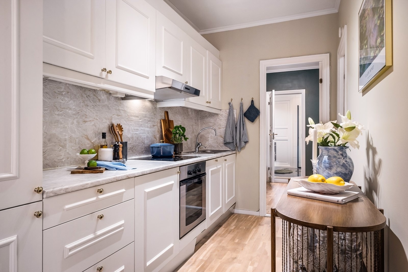 Lekkert kjøkken i hvit utførelse med profilerte fronter og laminert benkeplate. Malt i 2021. Galleribilde