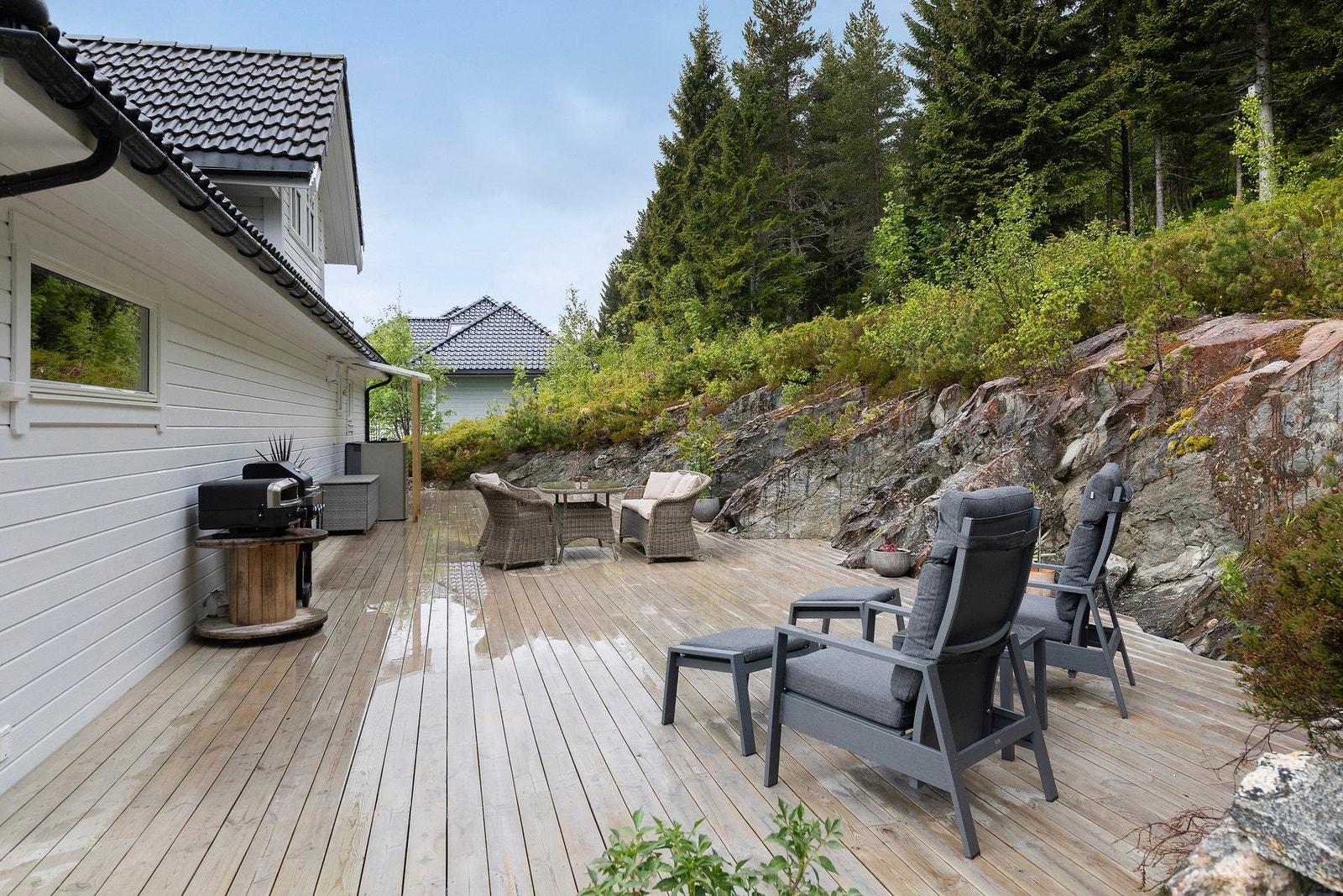 Stort uteområde med platting, balkong og drivhus. Galleribilde