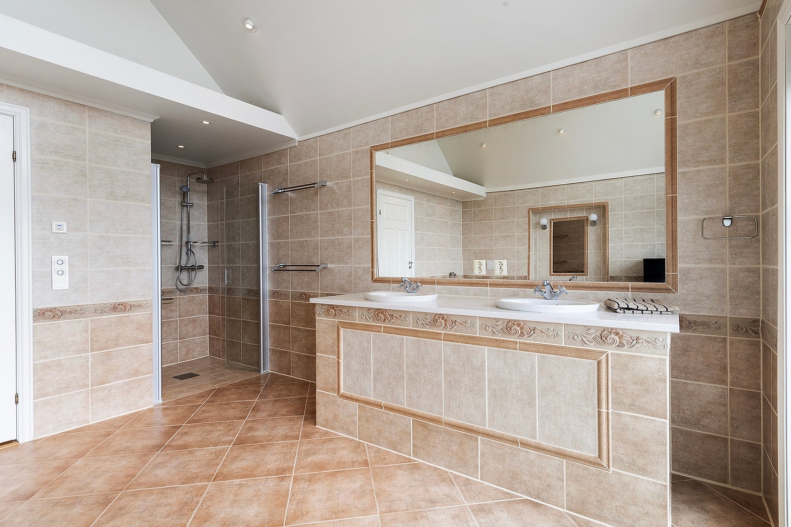 Badet i 1. etasje har både badekar og dusj. Romslig med dobbelvask og store vindusflater. Galleribilde