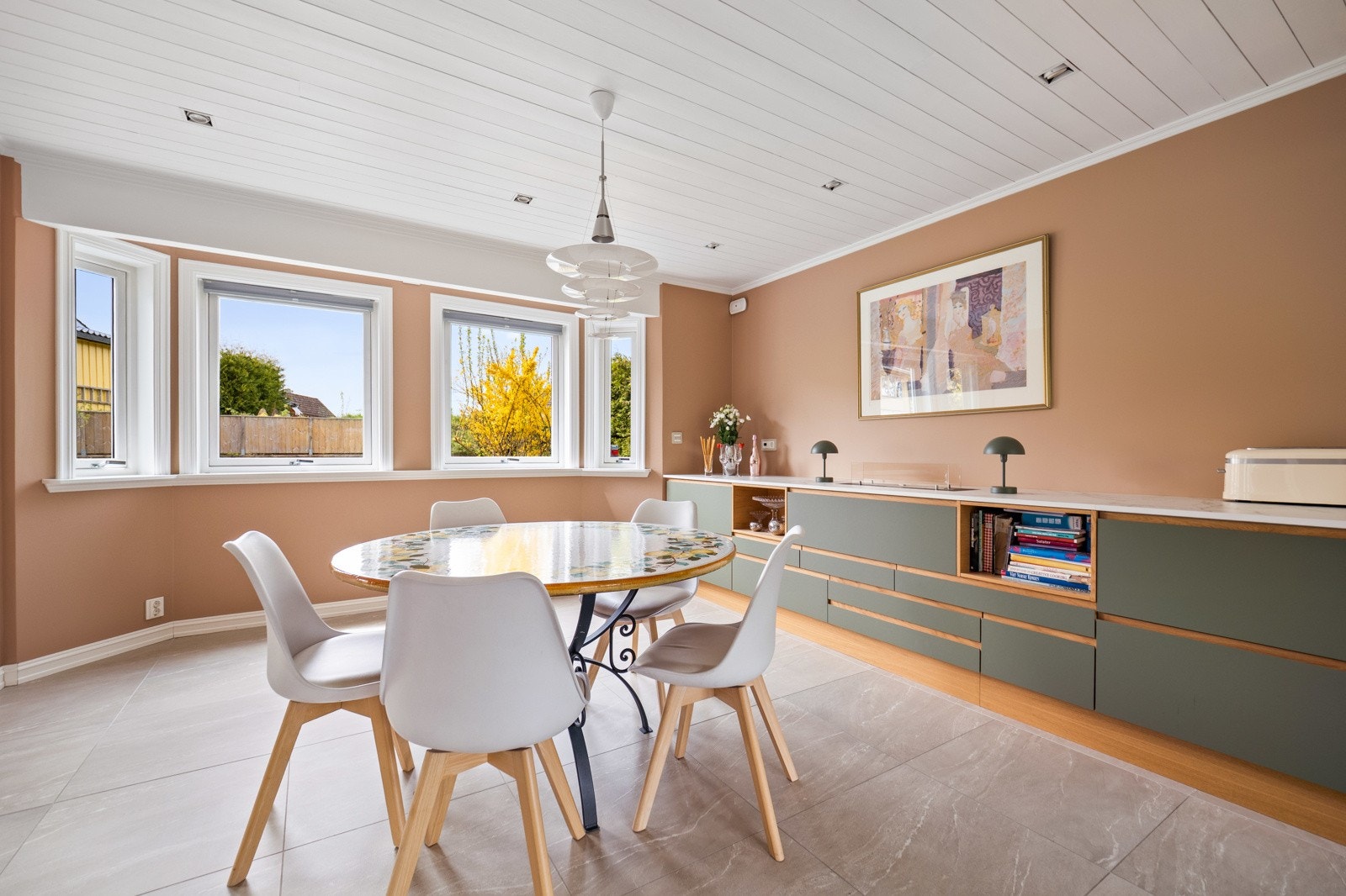 Rommet er malt i en lys terrakottafarge som gir lun stemning og en fin komplemetærkontrast til de grønne frontene. Galleribilde