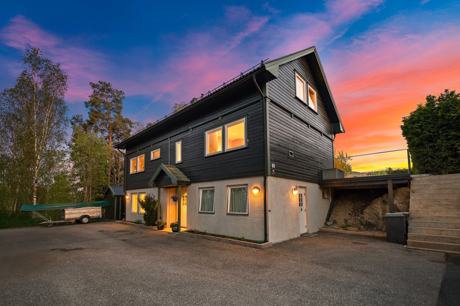 Eneboligen ligger innerst i veien, mot et lite skogholt, og har stor, asfaltert gårdsplass med elbillader. Galleribilde