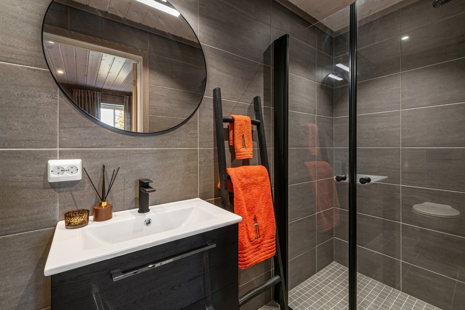 Badet er innredet med dusj, toalett og servant med innredning. Galleribilde