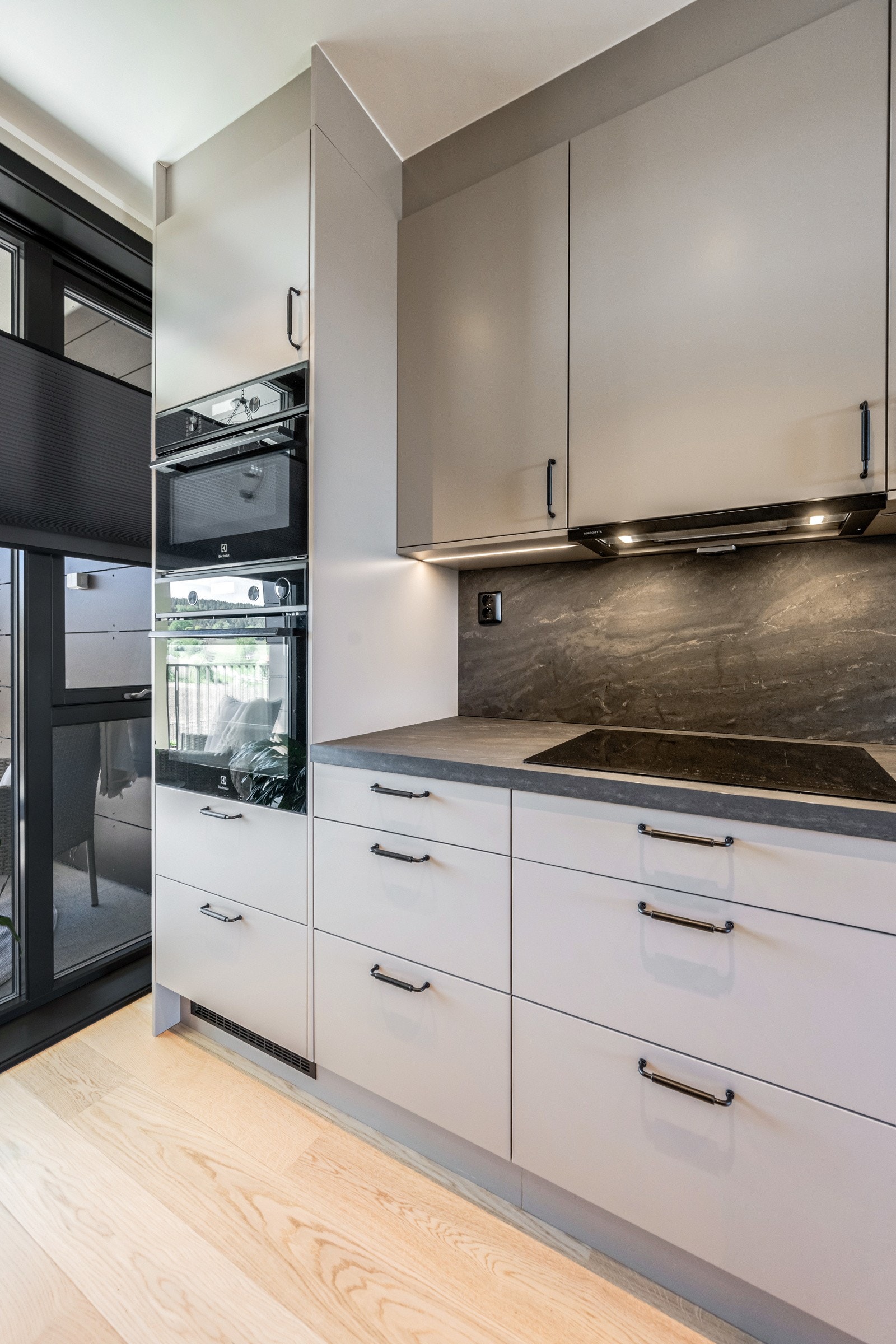 Kjøkkenet har moderne innredning med glatte fronter og benkeplate i laminat. Galleribilde