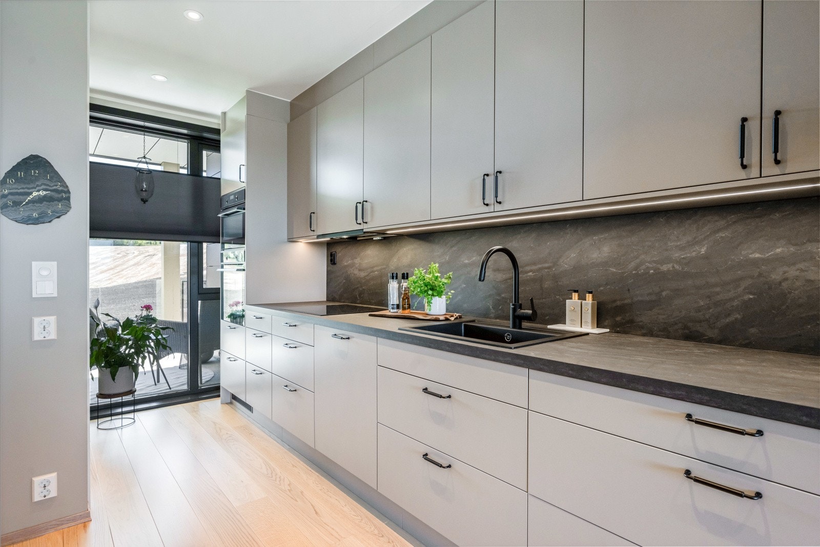 Moderne kjøkken med slette fronter og integrete hvitevarer. Galleribilde