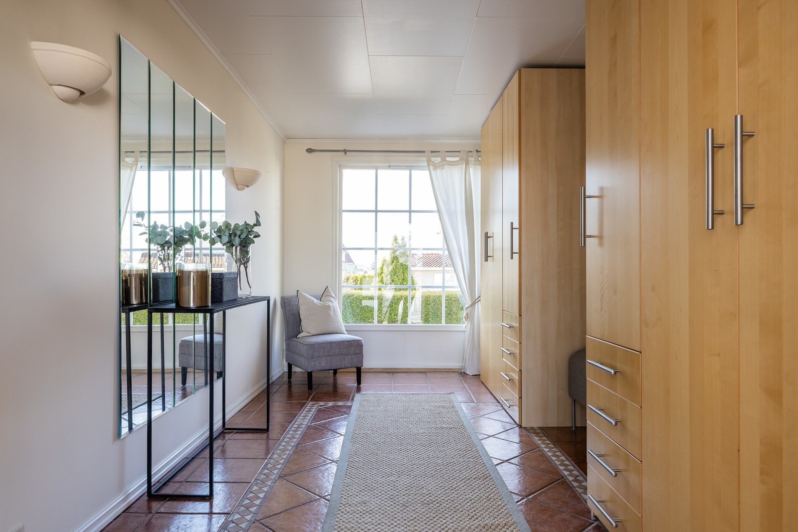 Boligen har en lys og romslig hall med store vindusflater som slipper inn rikelig med dagslys og skaper en innbydende atmosfære allerede ved inngangspartiet. Galleribilde