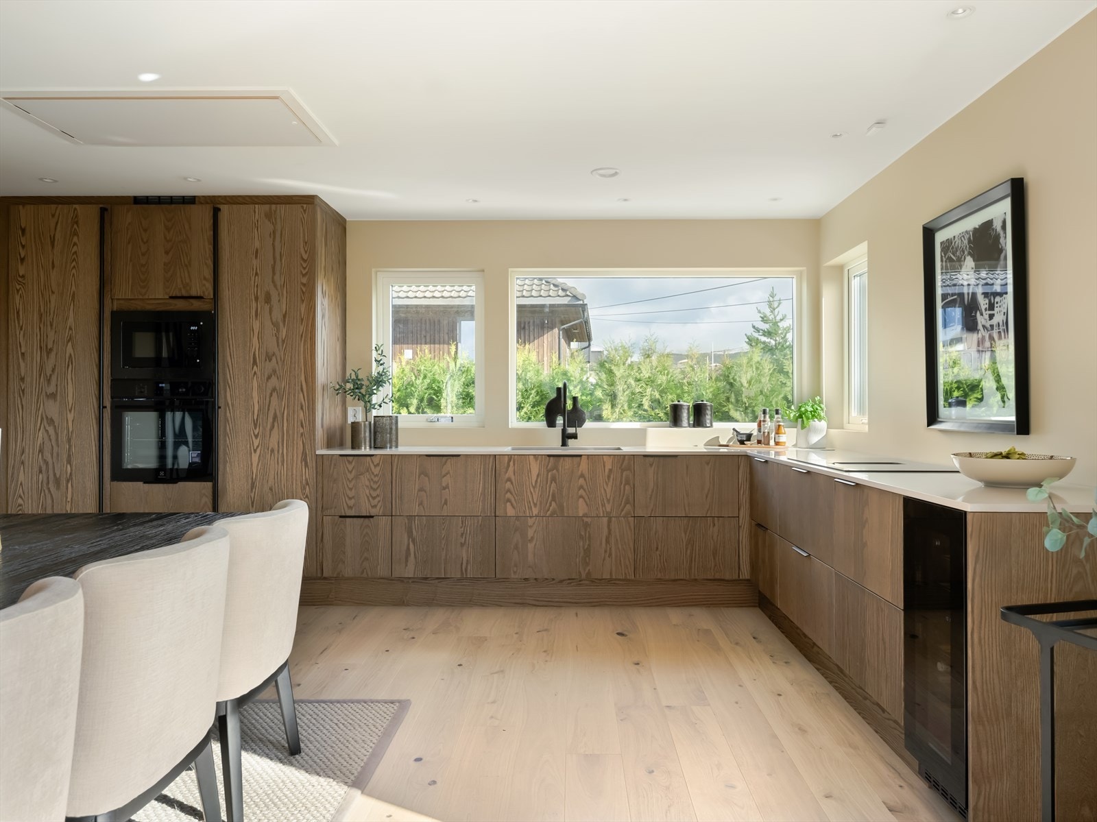 Kjøkkenet er utstyrt med integrerte hvitevarer fra kvalitetsleverandører som Electrolux og Bosch, inkludert kjøleskap, fyseskap, vinskap, stekeovn, mikrobølgeovn og oppvaskmaskin - alt sømløst innfelt for et helhetlig og moderne preg. Galleribilde