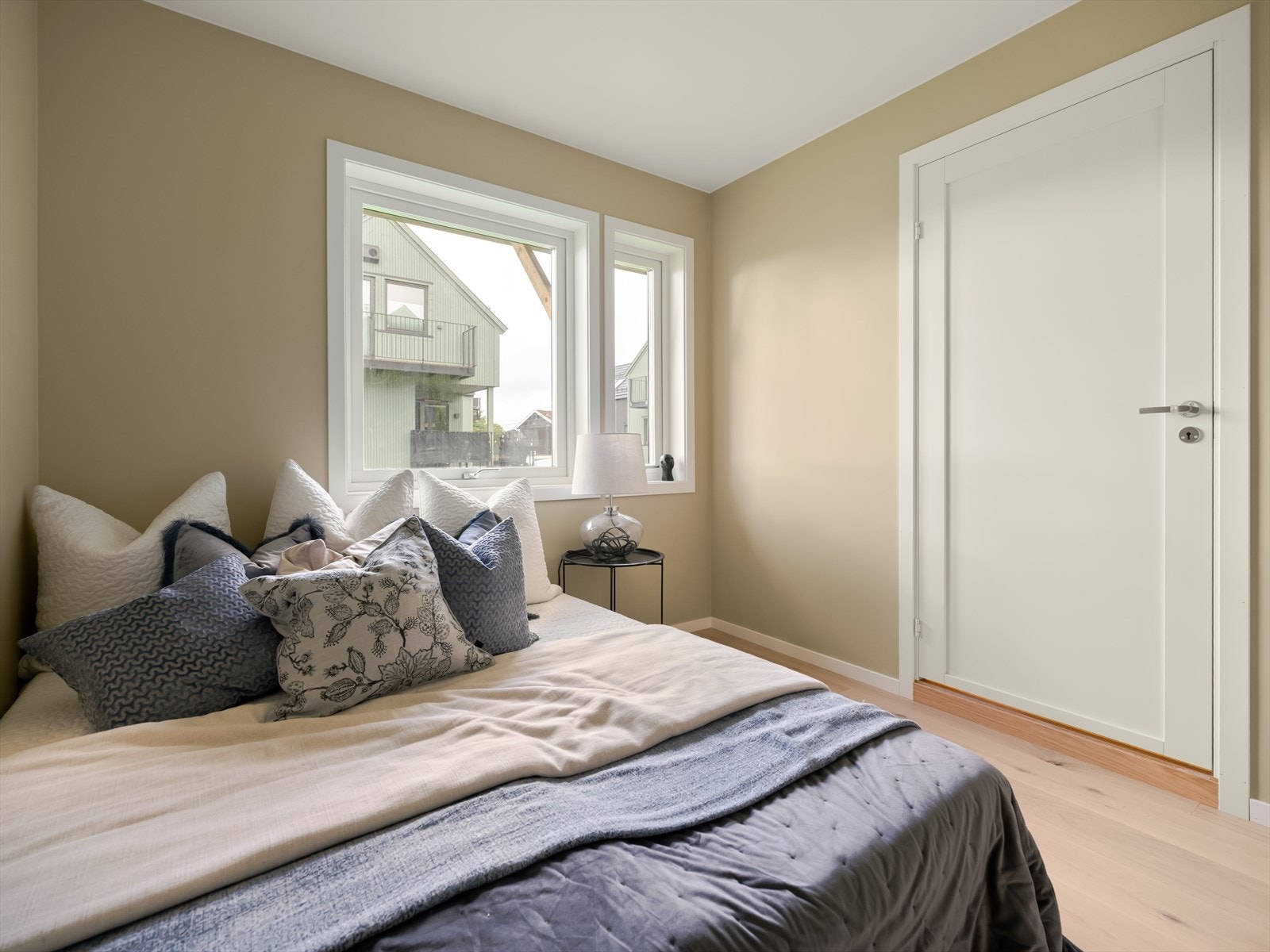 Store vinduer gir rikelig med naturlig lys, mens den nøytrale fargepaletten og lyse gulvet skaper en rolig atmosfære - perfekt som hovedsoverom, gjesterom eller et behagelig kontor. Galleribilde