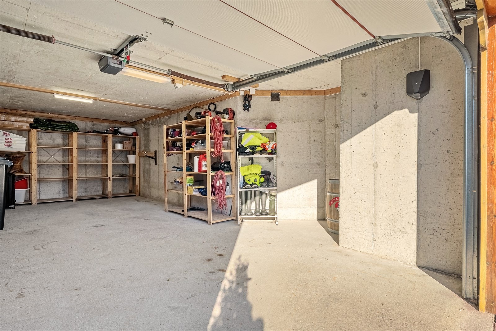 - Garasjen måler 33m² og har god plass til lagring av dekk, verktøy og annet utstyr. Det er også montert elbil-lader her - Galleribilde