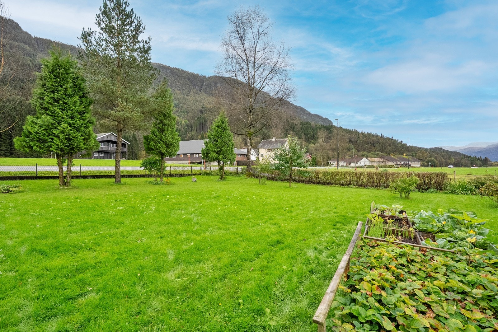 Eiendommen har en romslig tomt som er pent opparbeidet med velholdt hage, prydbusker og trær som gir en innbydende og harmonisk atmosfære. Galleribilde