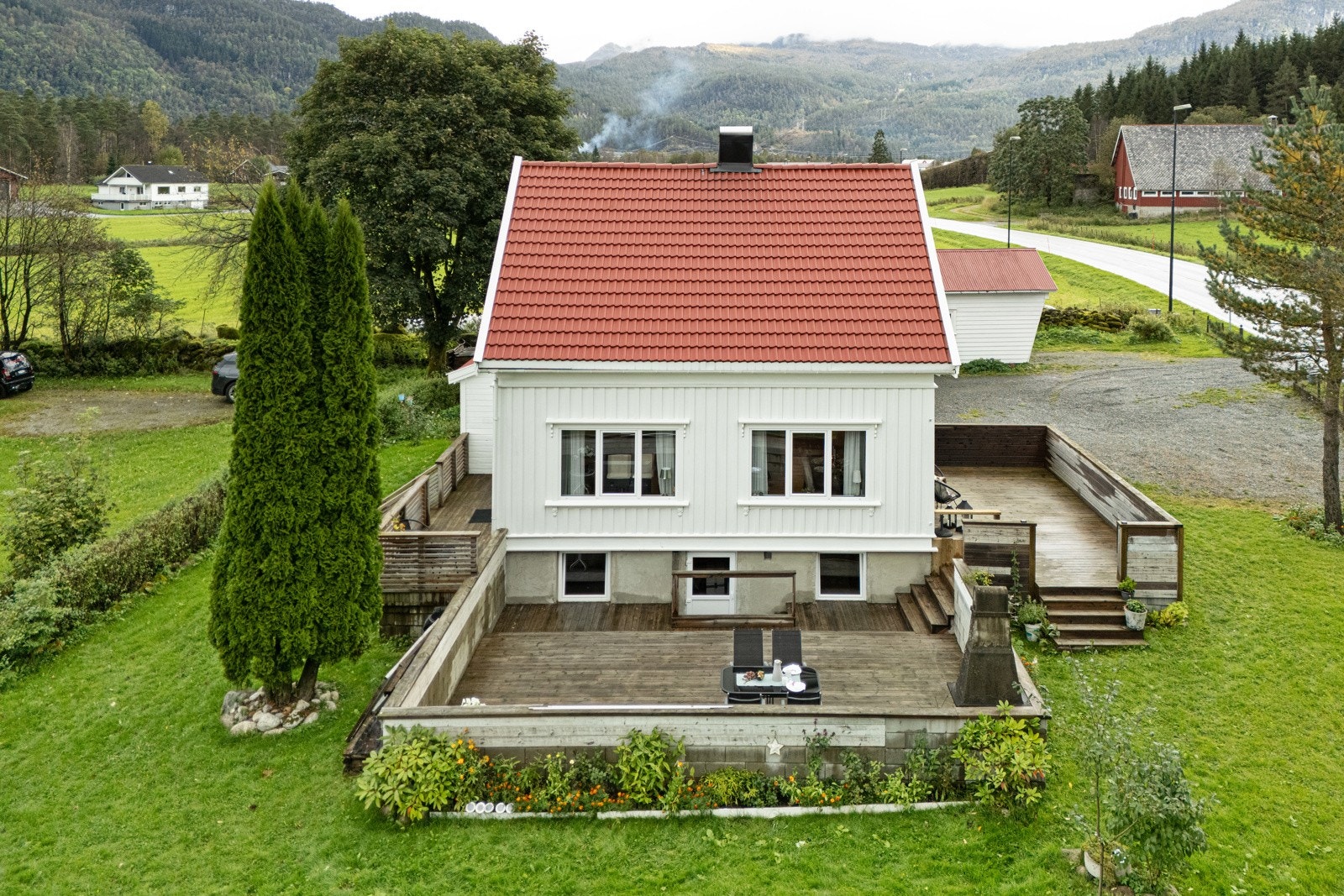 Eiendommen har en romslig tomt som er pent opparbeidet med velholdt hage, prydbusker og trær som gir en innbydende og harmonisk atmosfære. Galleribilde
