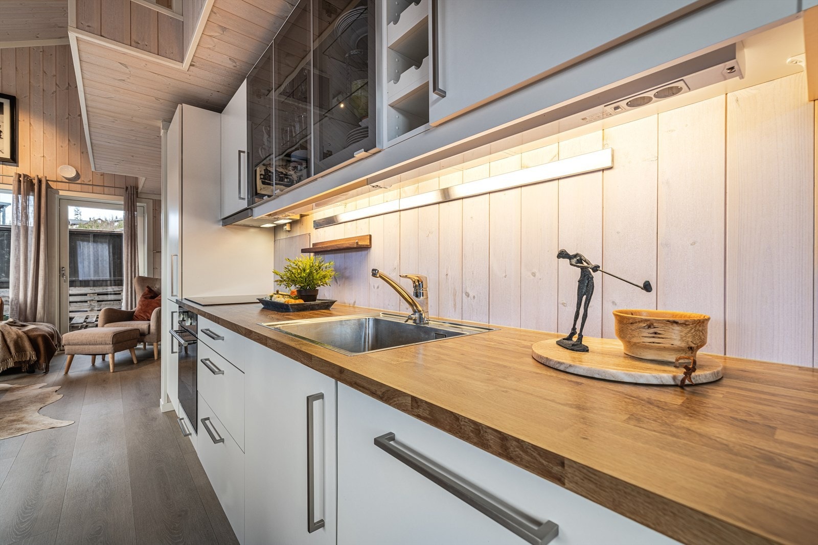 Lys og moderne kjøkkenløsning med stilrene detaljer og god utnyttelse av plass. Galleribilde