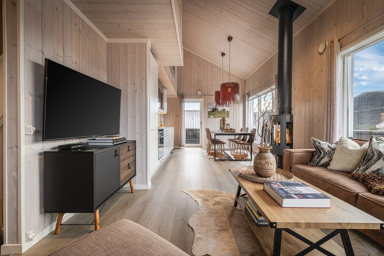 Allrommet med stue og kjøkken har generøs takhøyde og store vindusflater som gir godt med naturlig lys. Galleribilde