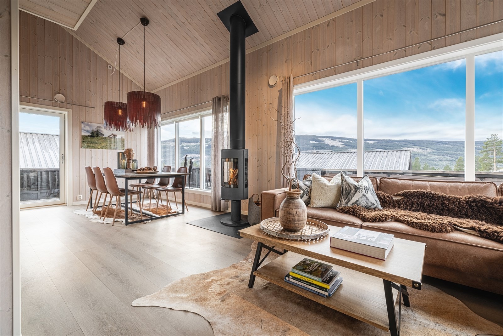 Stue med store vinduer som gir flott utsikt over naturskjønne omgivelser. Lys og luftig atmosfære. Galleribilde