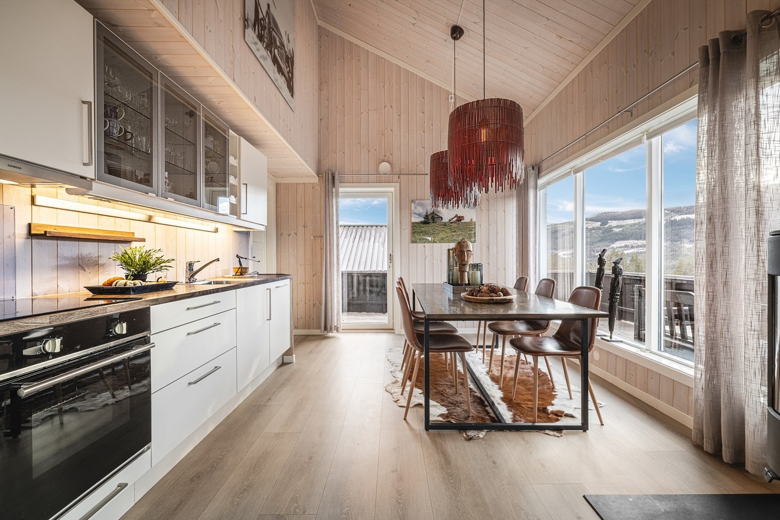 Lyst og delikat kjøkken med store vinduer og flott utsikt, perfekt for både hverdagsliv og gjestfrihet. Galleribilde