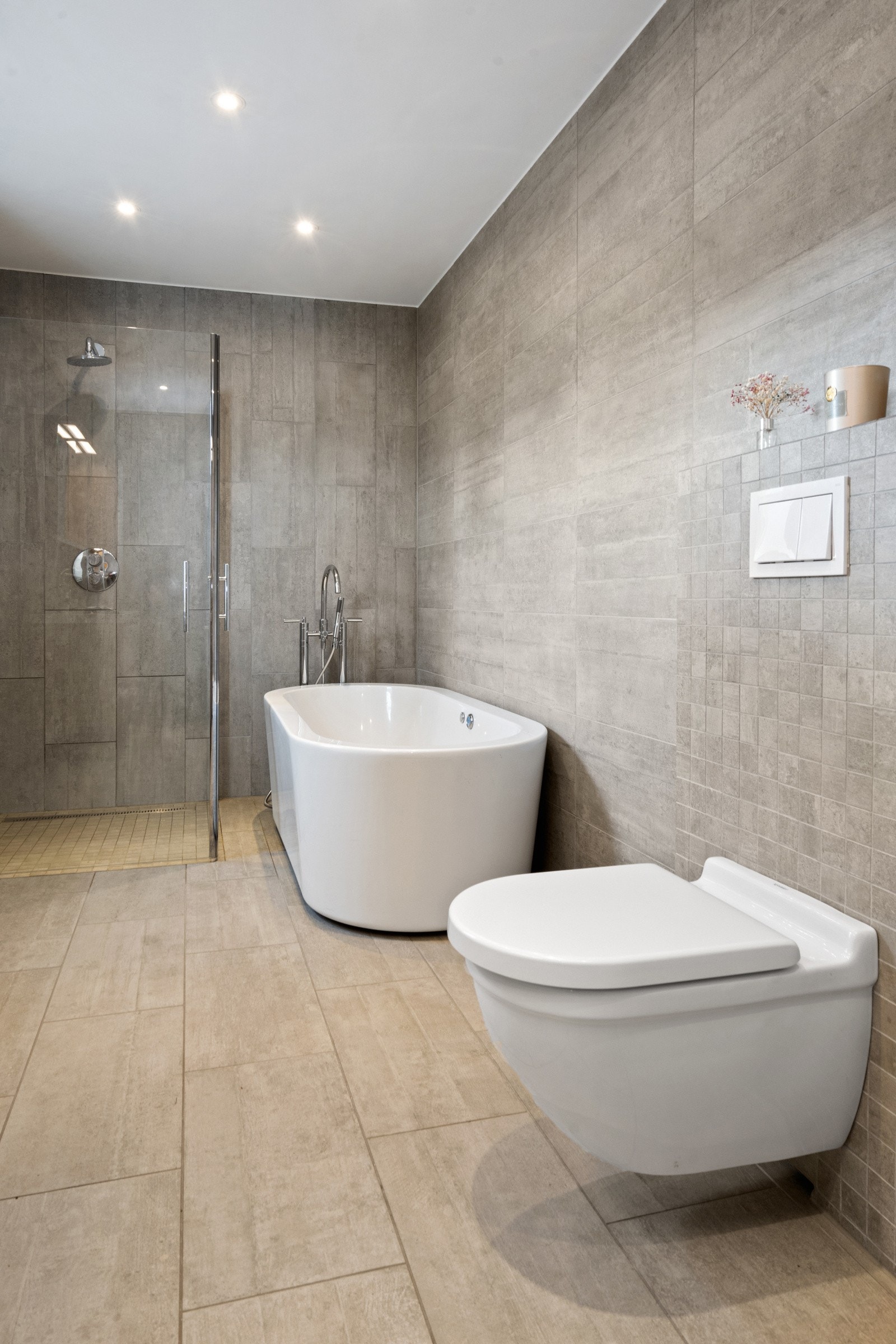 Lekkert flislagt bad fra ca. 2014 med varmekabler, moderne løsninger og delikate materialvalg. Galleribilde