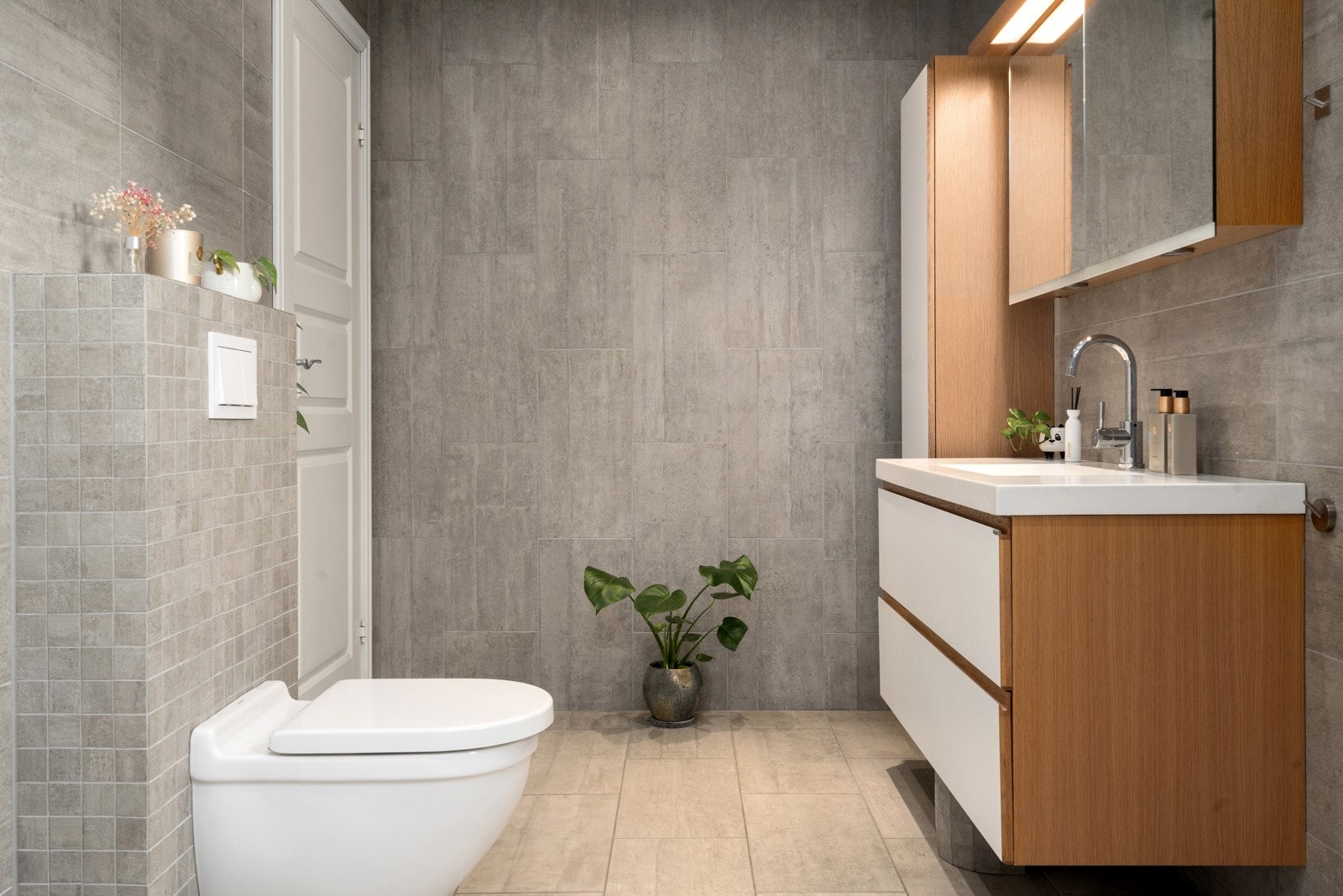 Vegghengt toalett og servantinnredning med heldekkende servant gir et rent og moderne uttrykk. Galleribilde