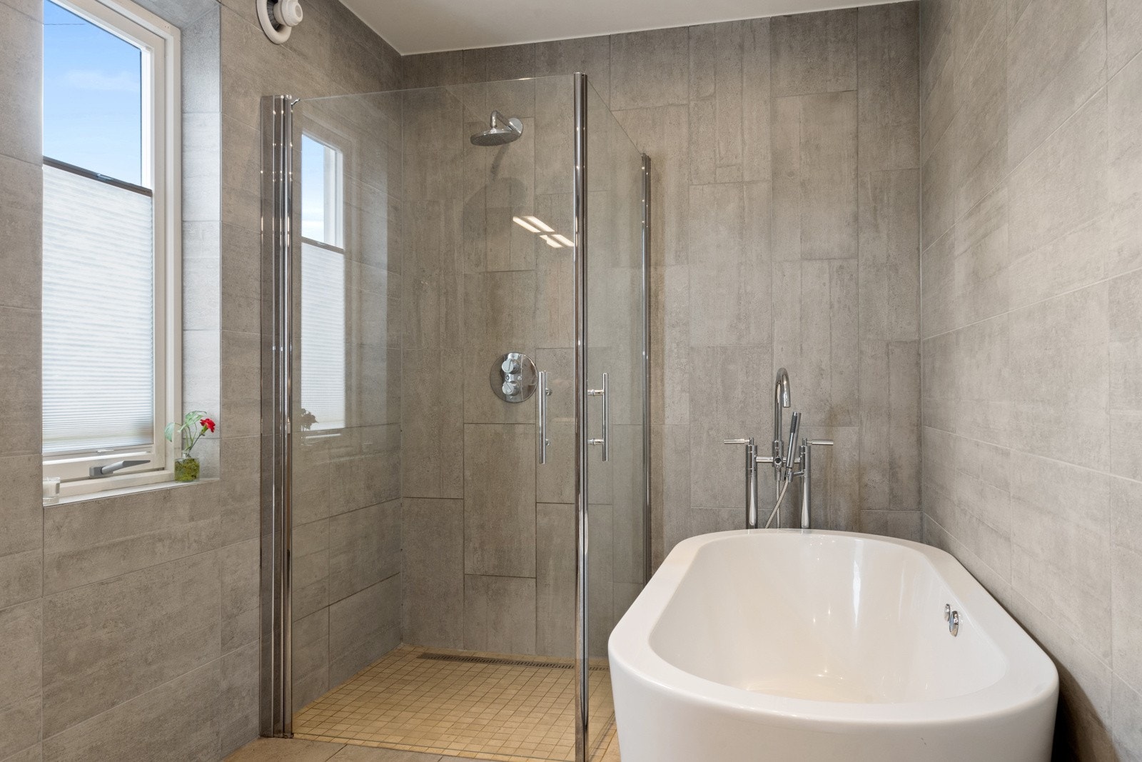 Stilrent uttrykk med moderne badekar, dusjnisje med glassdører og integrert regndusj. Galleribilde