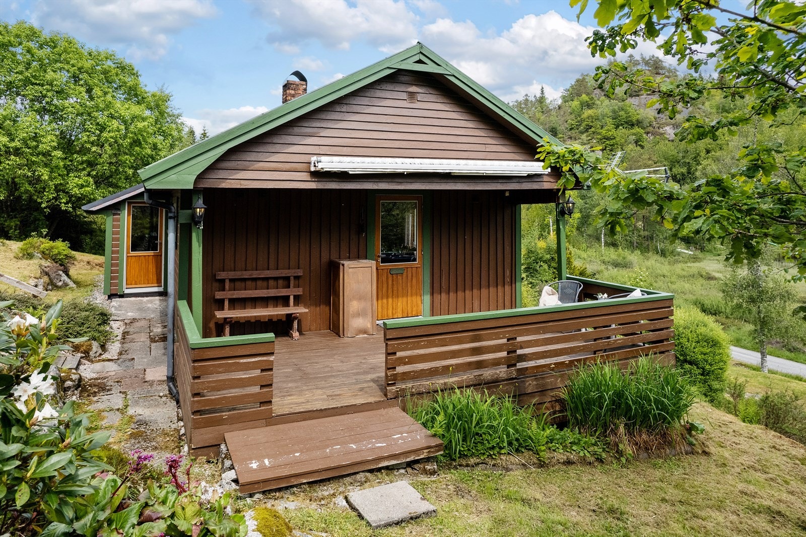 Terrasse i ende av hytte med takoverbygg. Markise. Galleribilde