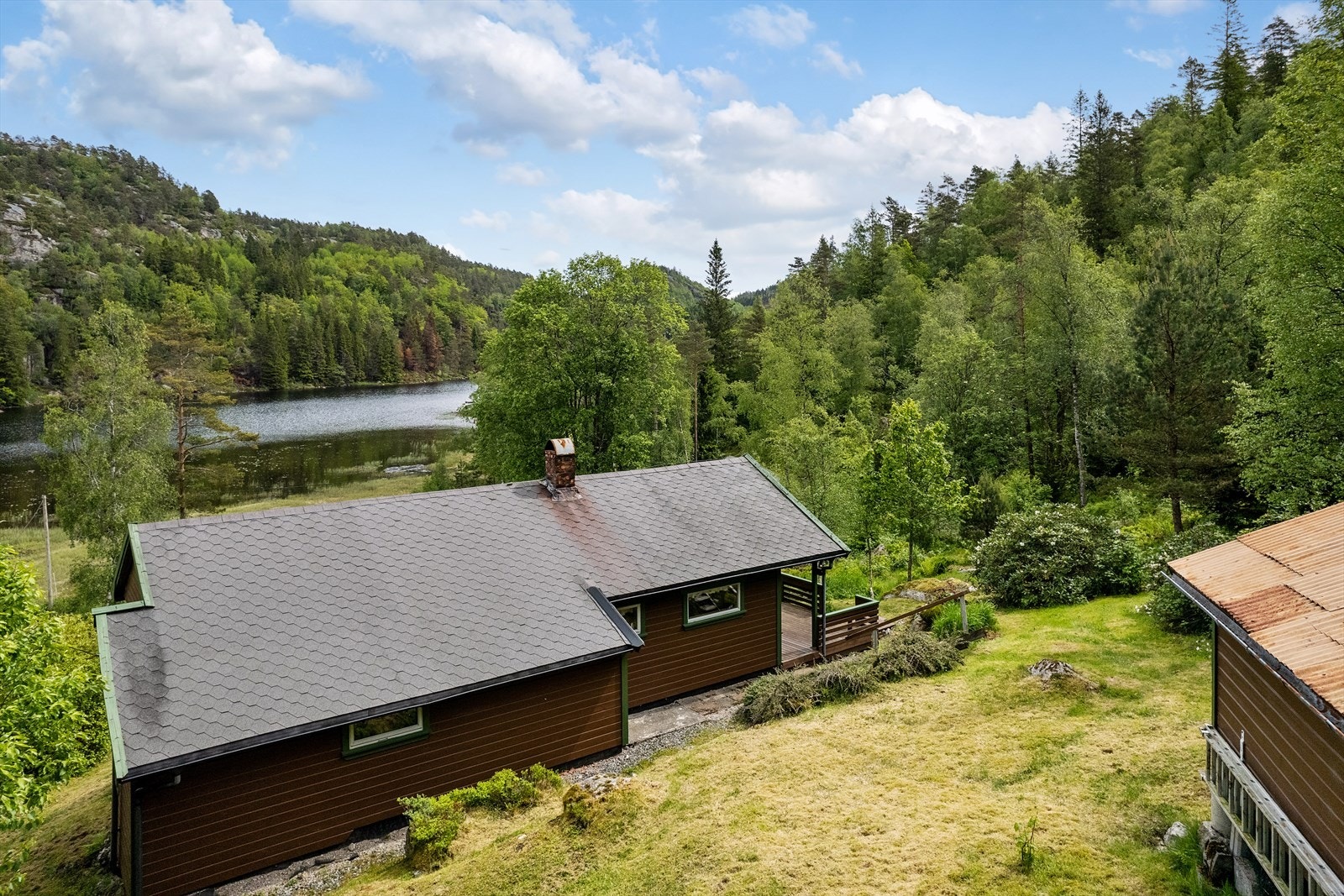 Bakside av hytte og utsikt mot Kleivvannet. Galleribilde