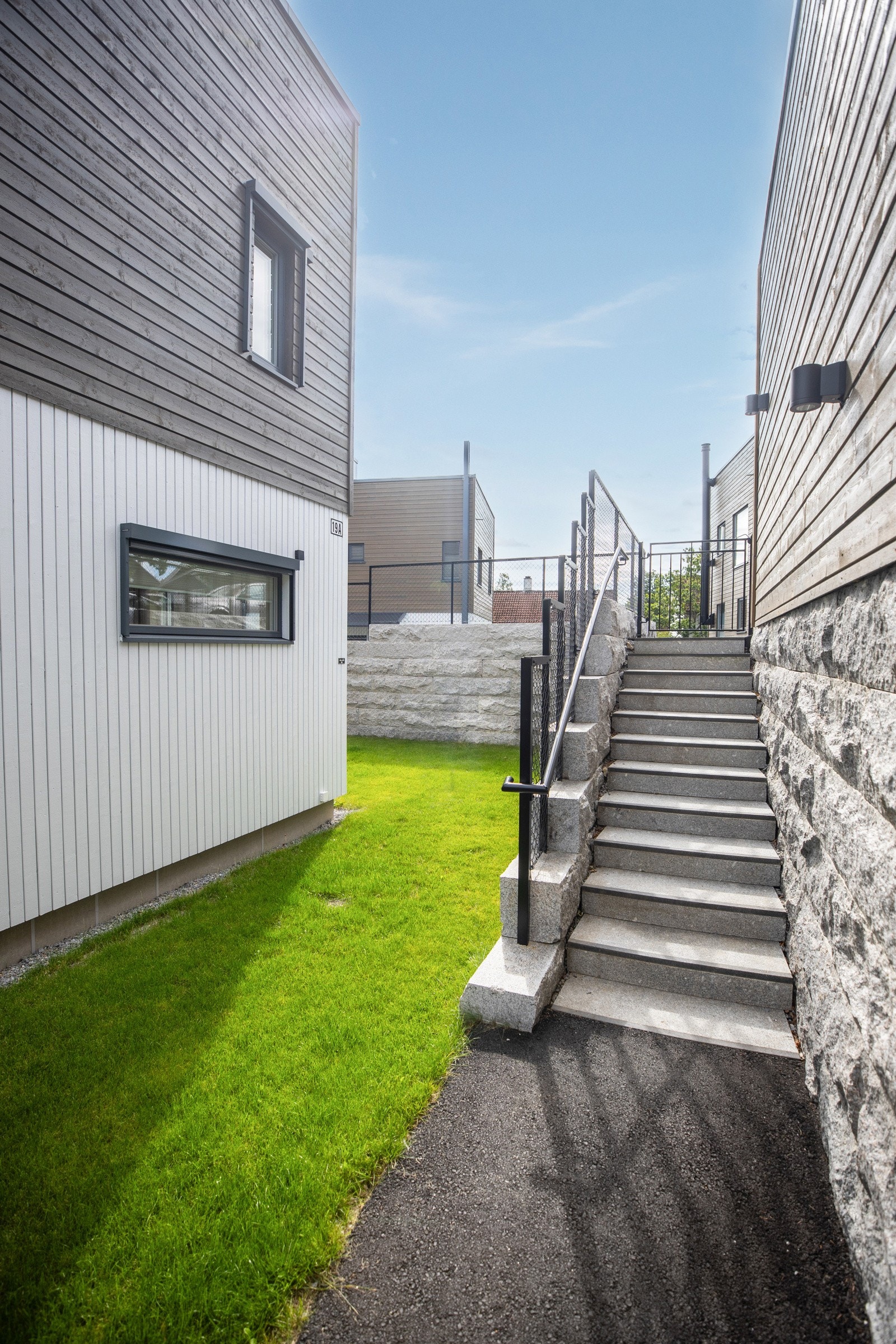 Fra carporten er det port og trapp ned til en asfaltert gangsti som leder frem til inngangspartiet. Galleribilde