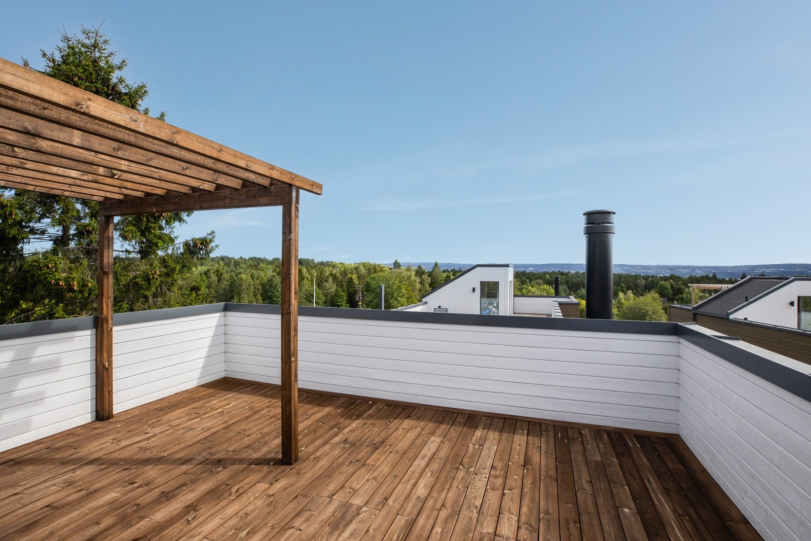 Takterrassen inviterer til sosiale sammenkomster, med skogkledd landskap som bakteppe. Galleribilde