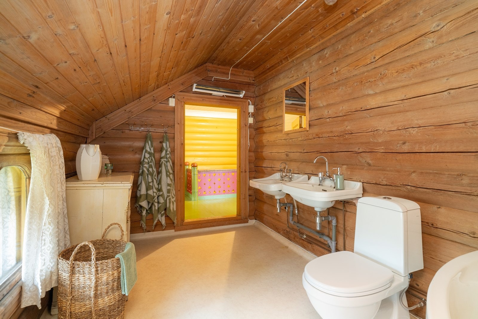 Badet har belegg på gulv med varmekabler, originale tømmervegger og trepanel i tak. Galleribilde