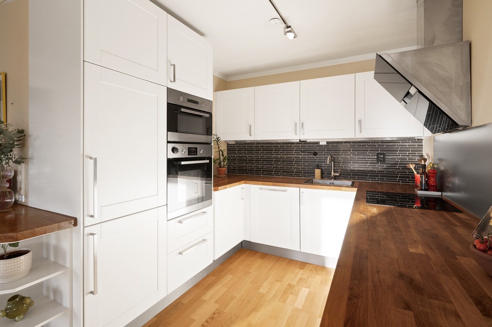 Romslig kjøkken i åpen løsning med integrerte hvitevarer (medfølger) og stor arbeidsbenk Galleribilde