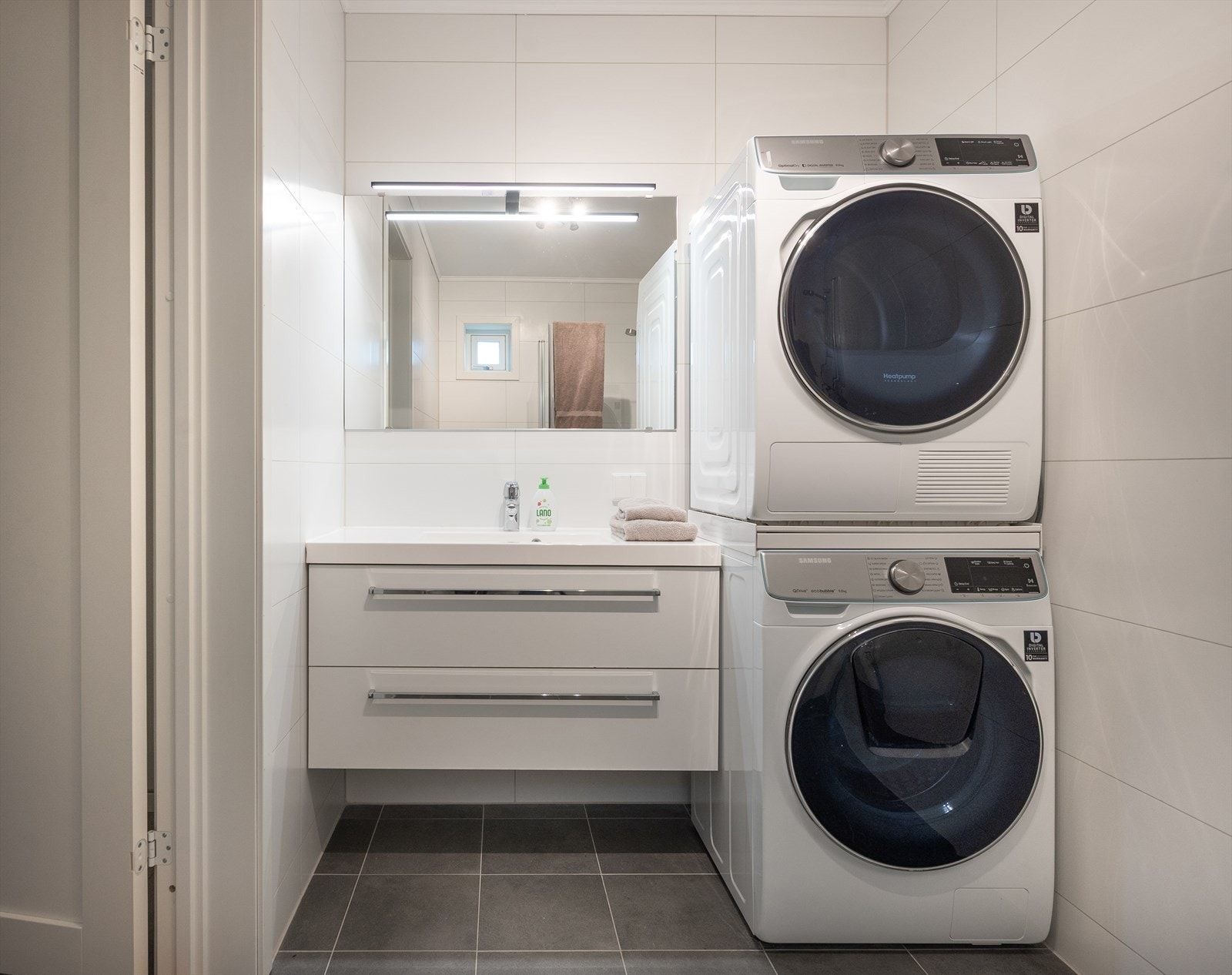 Her er innredningen godt planlagt, så vaskemaskin og trommel blir integrerte deler ved siden av servanten. Galleribilde