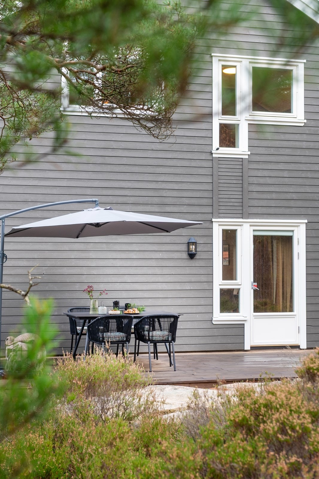 Boligen er gråmalt med hvite karmer og gavler. Stilen er tidløs og kommer til å vare, dog med noen raffinerte felt der kledningen er smalere, og et spennende innhogg i taket, der to takvinduer står i vinkel med to veggvinduer. Galleribilde