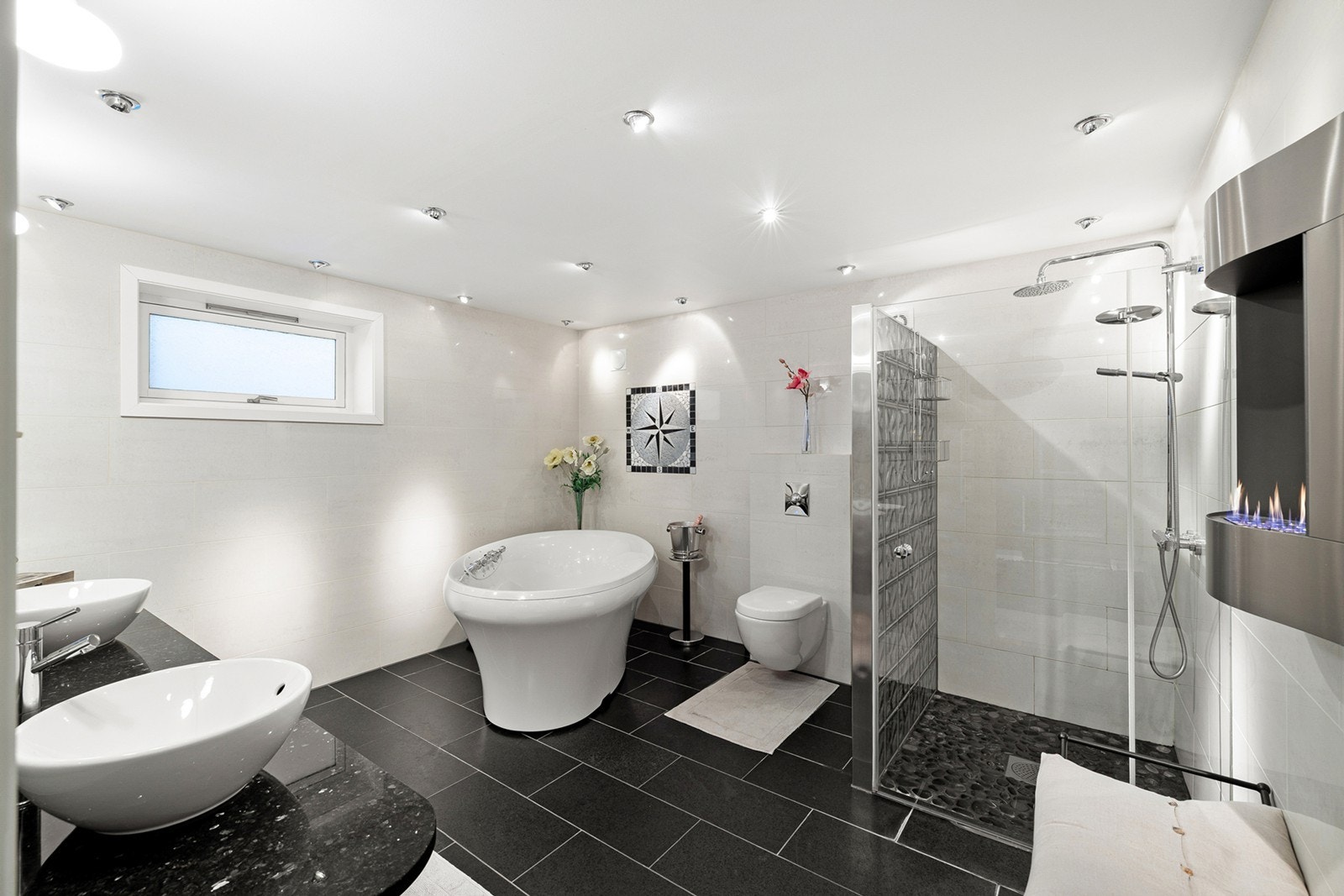 Lyst og delikat flislagt bad med elektriske varmekabler i gulv og downlights i himling. Badet ligger i direkte tilknytning til soverommet og ble utvidet og oppgradert i 2007. Galleribilde