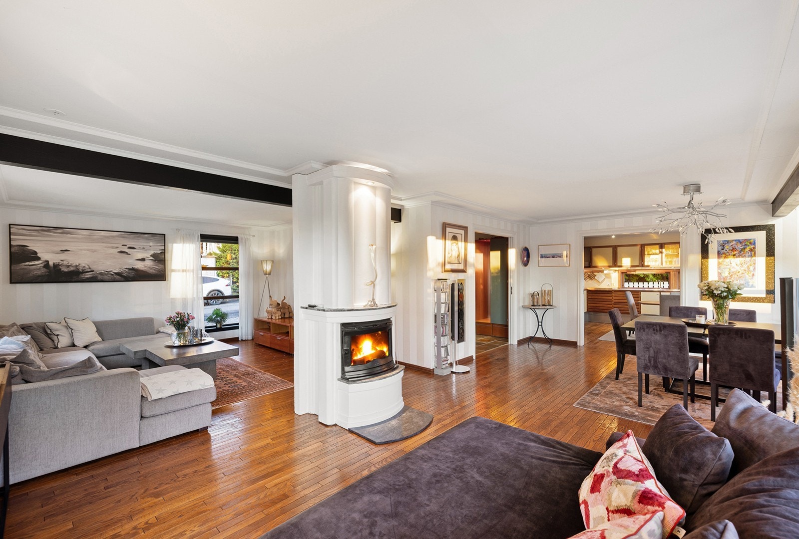 Lyst og romslig oppholdsrom med flott peis, store vindusflater og god plass til både sofakrok og spisegruppe. Galleribilde