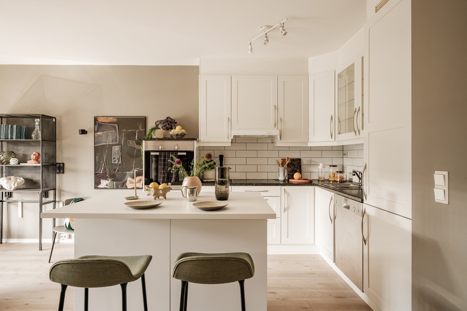 Kjøkkenet er moderne og tidløst, med lyse, malte skapfronter og en praktisk benkeplate i laminat som gir rikelig med arbeidsflate. Galleribilde