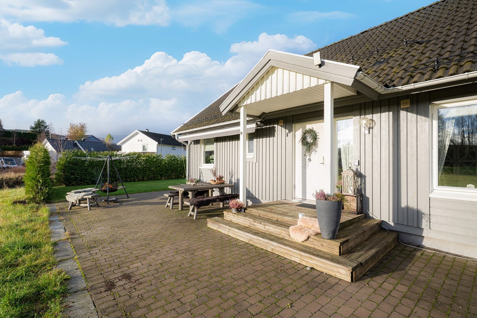 Ved det hyggelige inngangspartiet er det god plass til diverse utemøbler samt en idyllisk bålpanneplass. Det er montert markise på veggen for solskjerming. Galleribilde