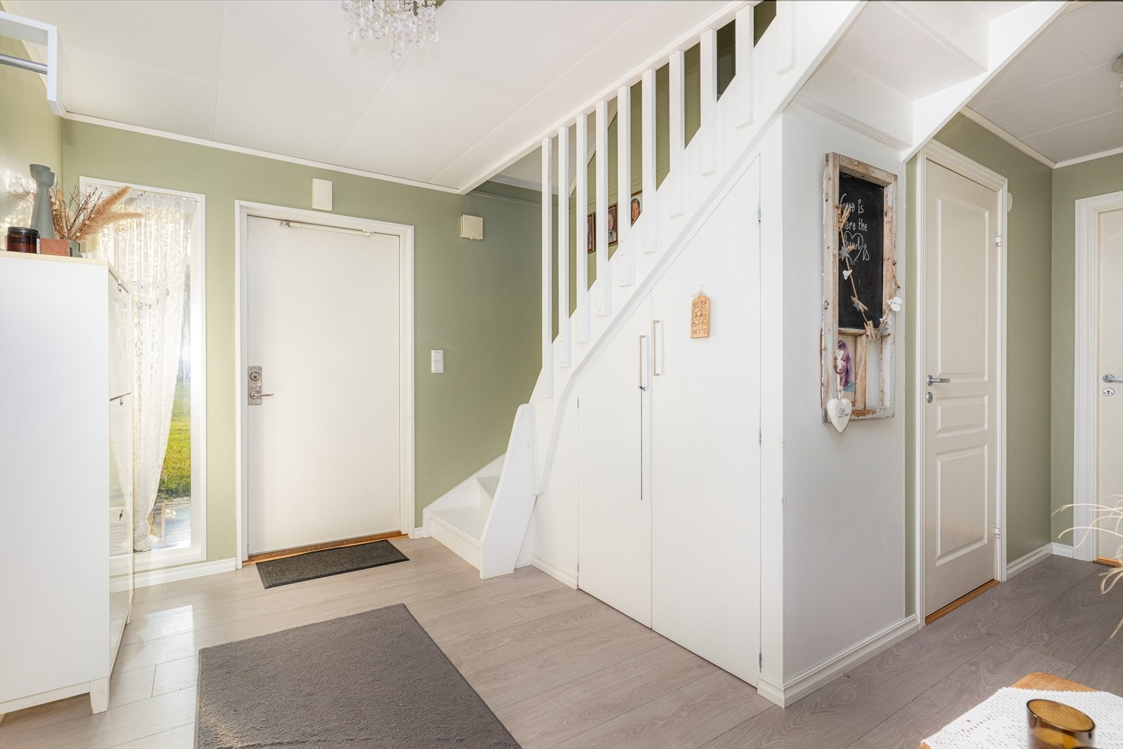 Med adkomst fra det hyggelige inngangspartiet kommer man inn i en lys og romslig gang. Under trappa opp til 2. etasje er plassen godt utnyttet med en praktisk bodplass. Galleribilde