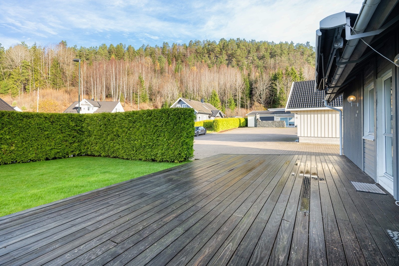 Terrassen på motsatt side av boligen har adkomst fra kjøkkenet. Terrassen har levegg mot sydvest, og også her er det god plass til utemøbler, grill og blomster m.m. Galleribilde