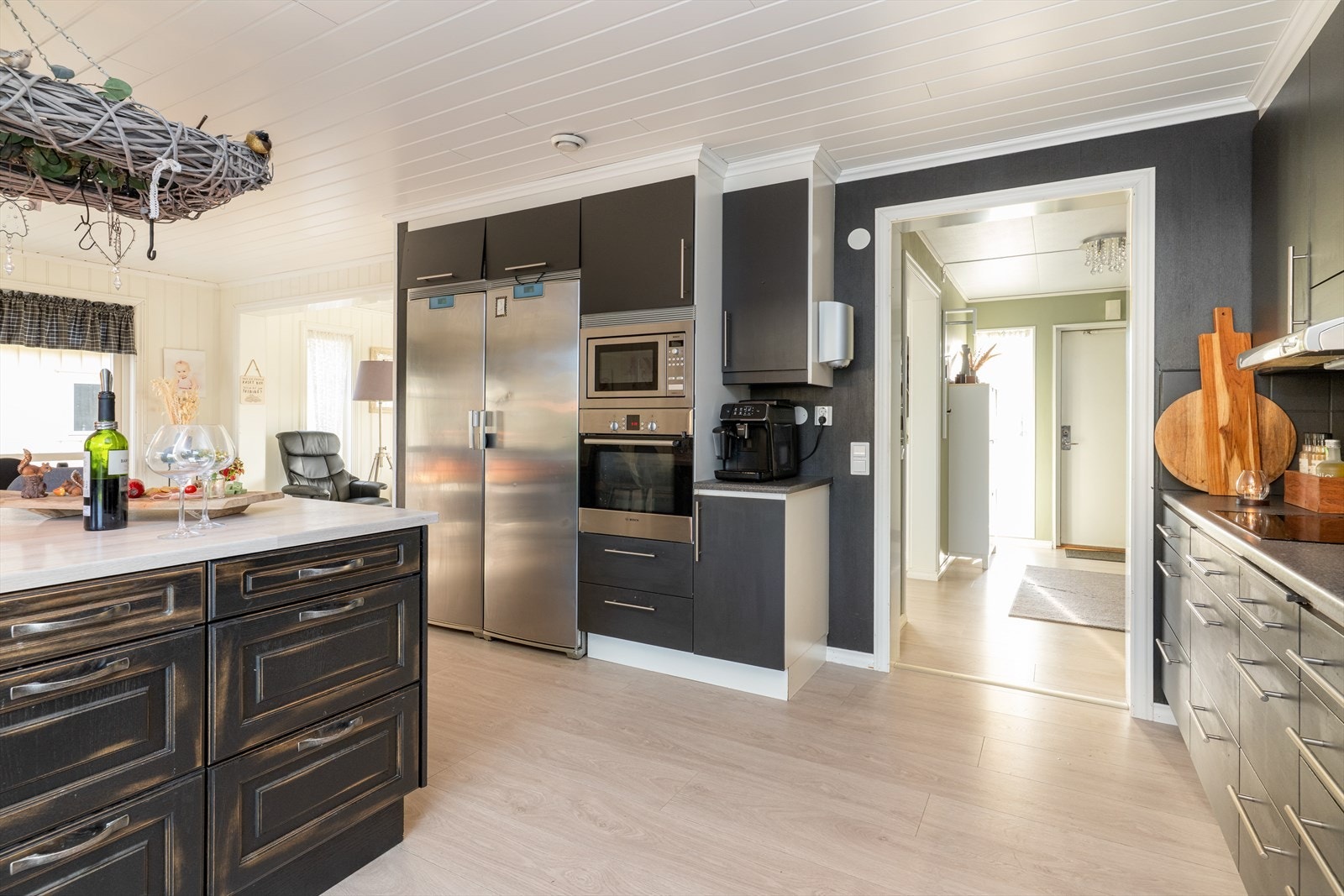 Kjøkkenet har integrert oppvaskmaskin og koketopp, samt seksjon med høyskap hvor integrert stekeovn og mikro er plassert i praktisk arbeidshøyde. Det er avsatt plass til frittstående side-by-side kjøle- og fryseskap. Galleribilde