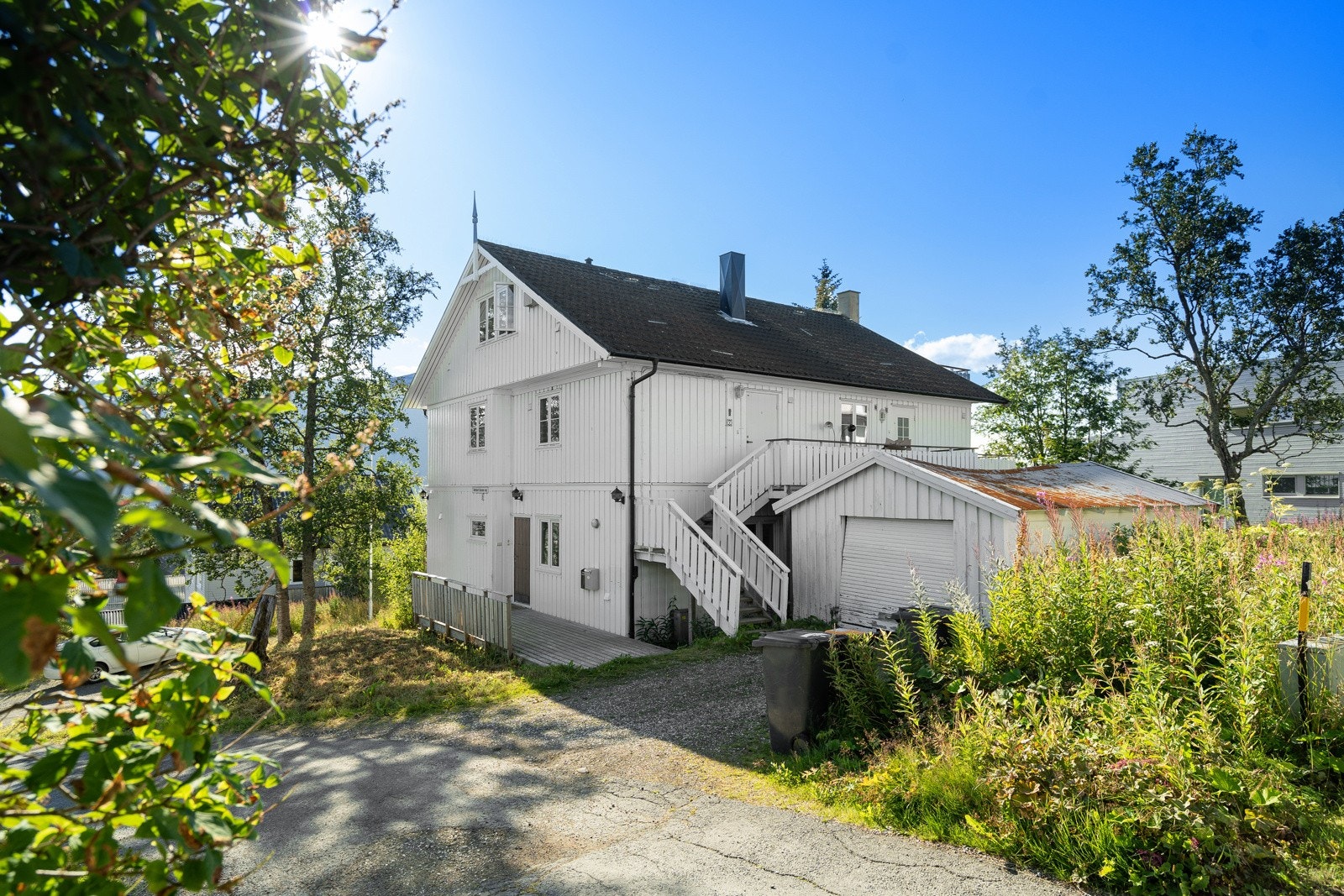 Bilen kan parkeres på den gruslagte felles gårdsplassen.