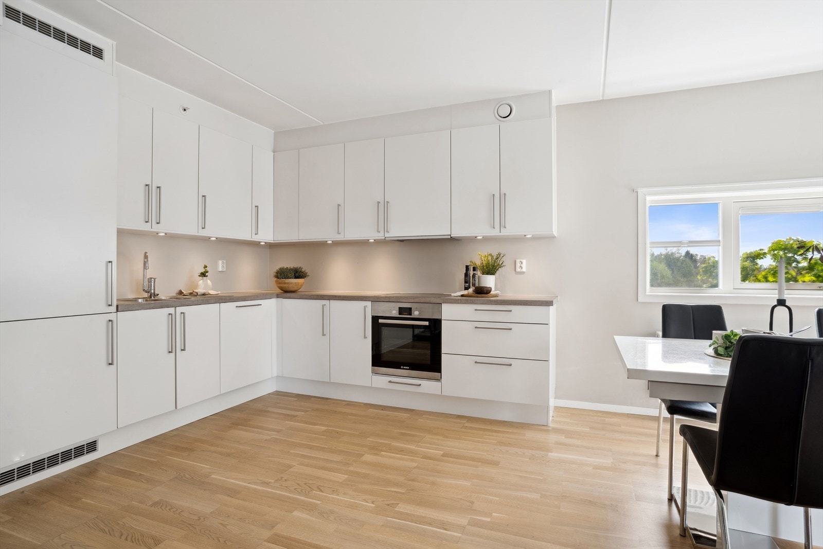 Klassisk kjøkken med hvite fronter og stålhåndtak som skaper en fin balanse og gir deg en følelse av ro mens du lager mat. Galleribilde