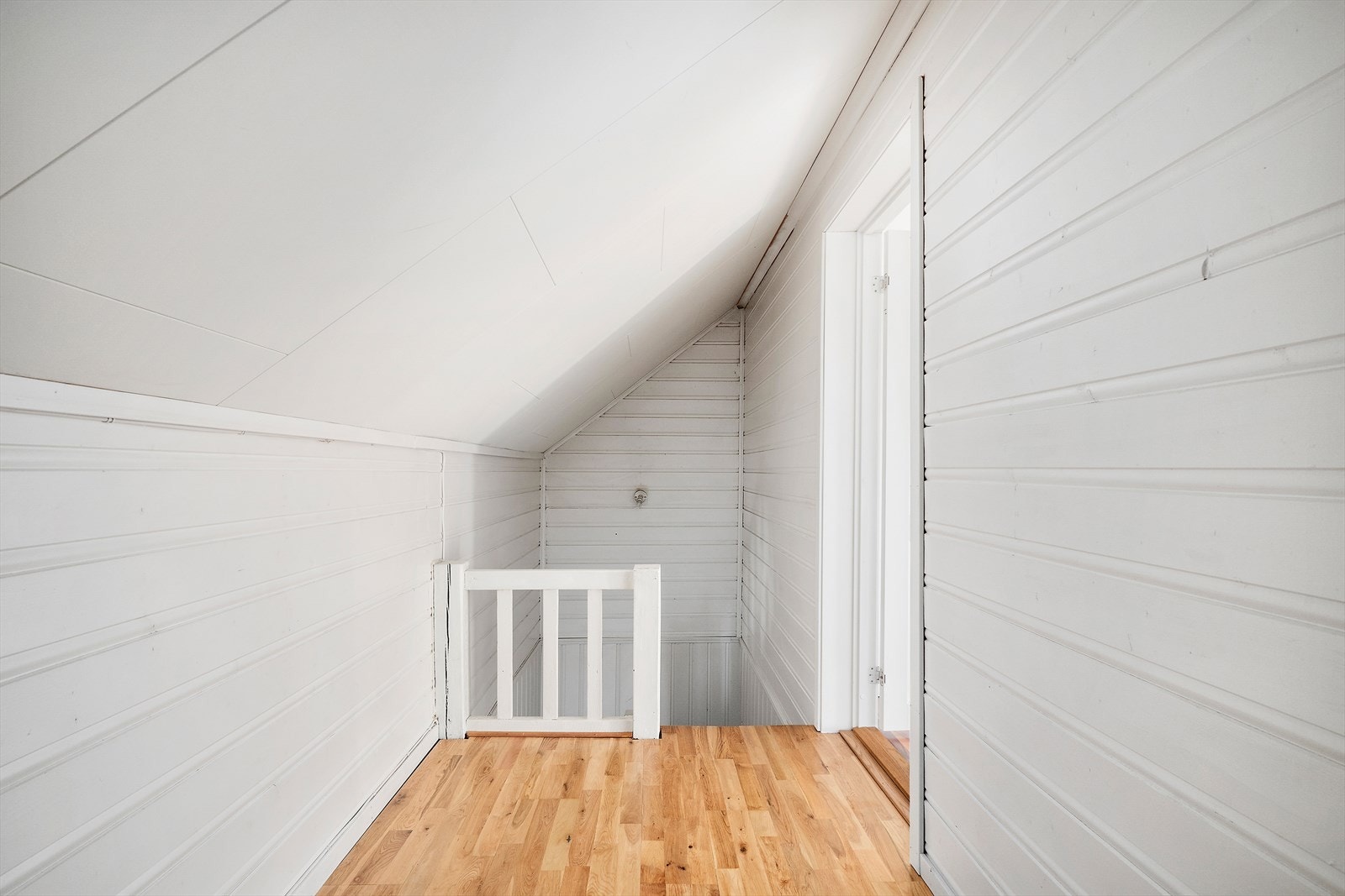 Åpen gang med lyst tregulv som binder sammen soverommene i andre etasje. En praktisk løsning som gir en luftig følelse og god flyt i boligen. Galleribilde