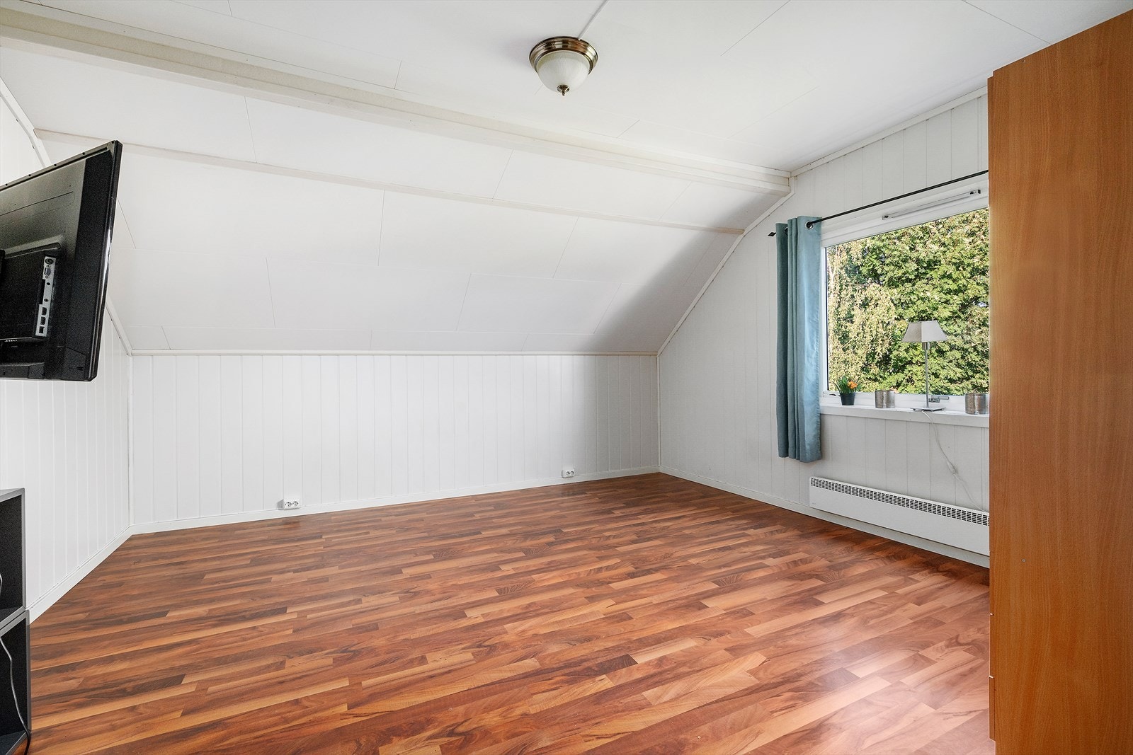 Et koselig rom med skråtak og vindu med utsikt mot grønne omgivelser. Passer perfekt som barnerom, gjesterom eller hjemmekontor - fleksibilitet tilpasset dine behov. Galleribilde