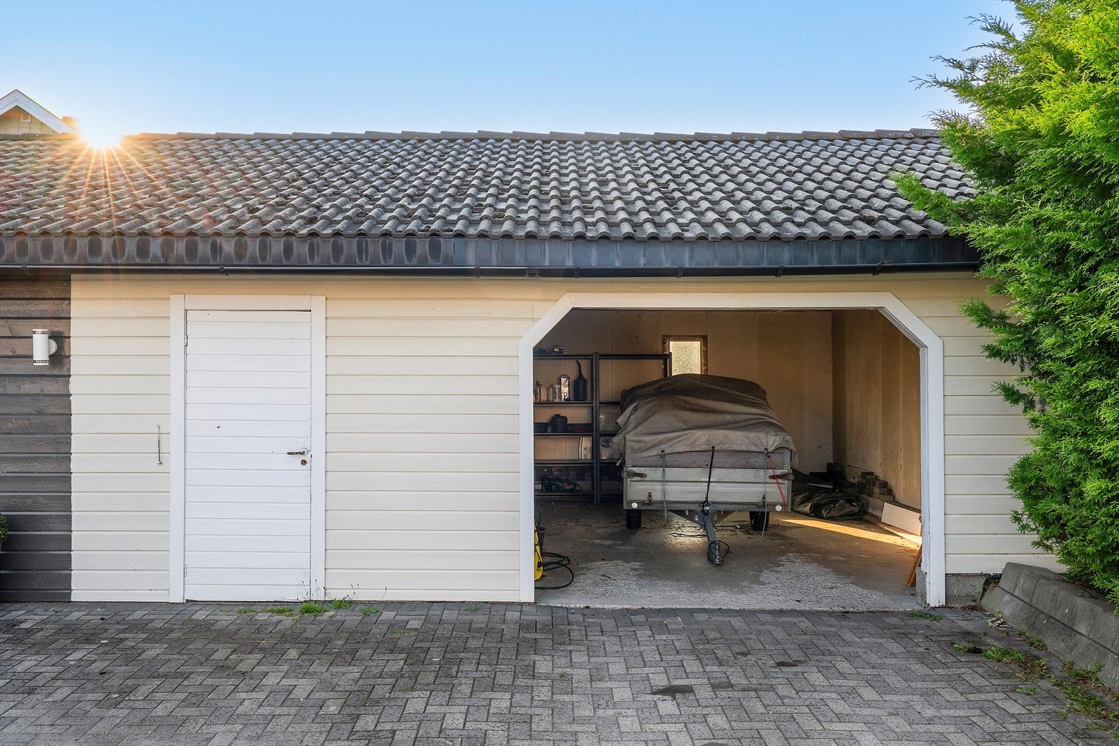 Medfølgende garasje med god plass til bil og ekstra oppbevaring. Praktisk sideinngang og brolagt innkjørsel gir enkel adkomst. Galleribilde