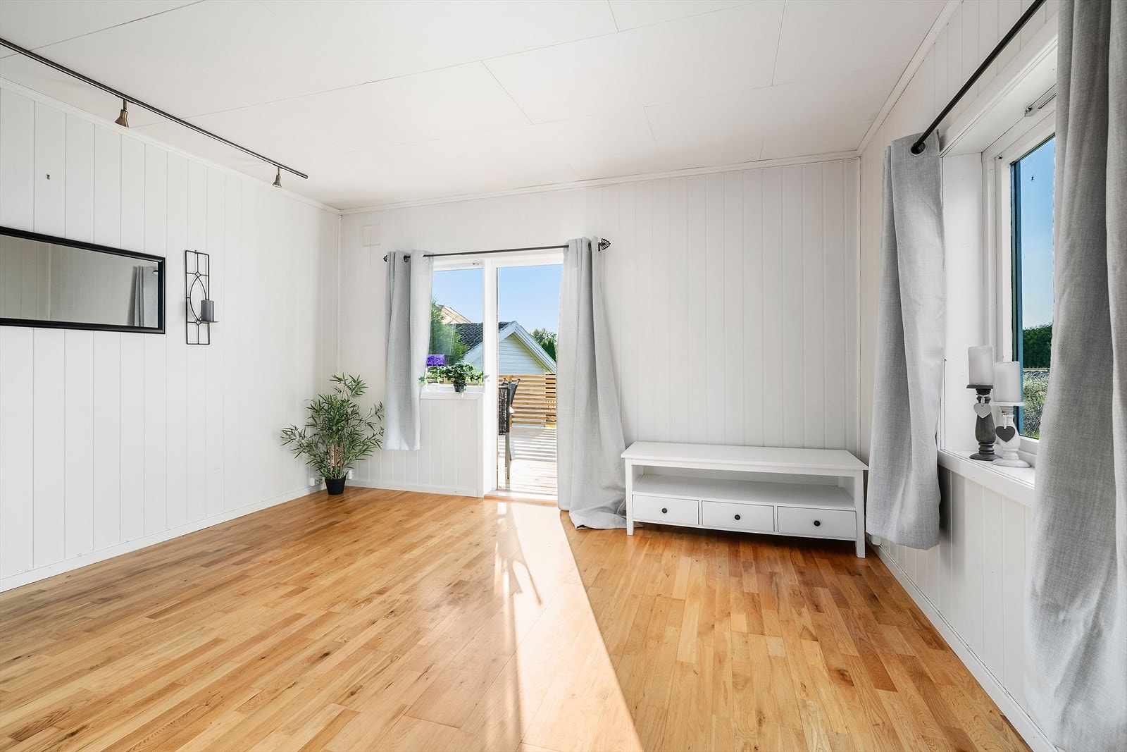 Romslig og lys stue med store vindusflater som gir godt med naturlig lys. Her er det plass til både sofakrok og spisebord, og glassdøren gir direkte utgang til uteområdet. Ideelt for sosiale sammenkomster og familieliv. Galleribilde