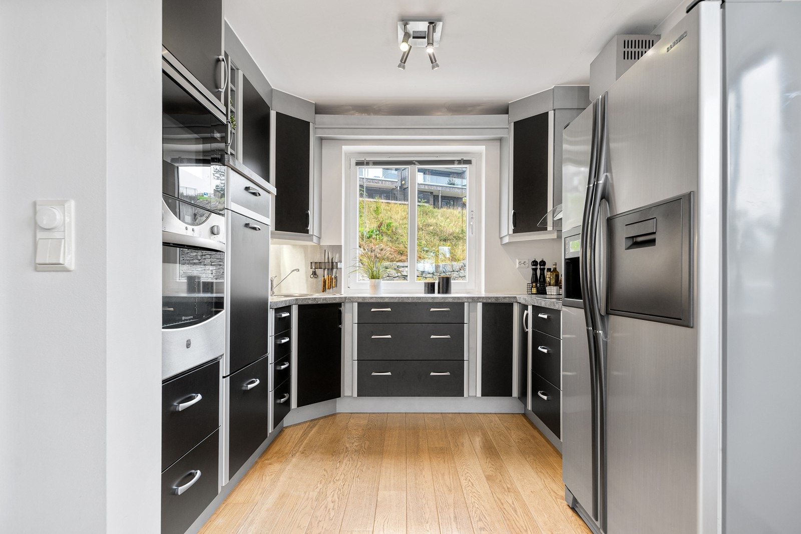 Pent kjøkken med slette fronter og rikelig med oppbevaring i skuffer og skap Galleribilde