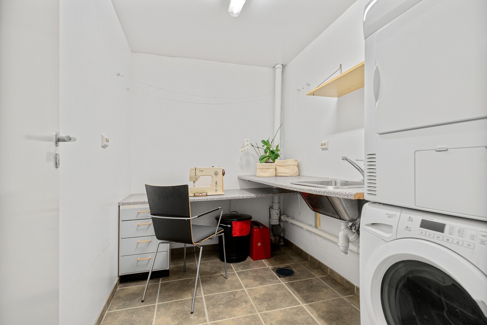 Praktisk vaskerom med flislagt gulv, varmekabler og opplegg for vaskemaskin Galleribilde