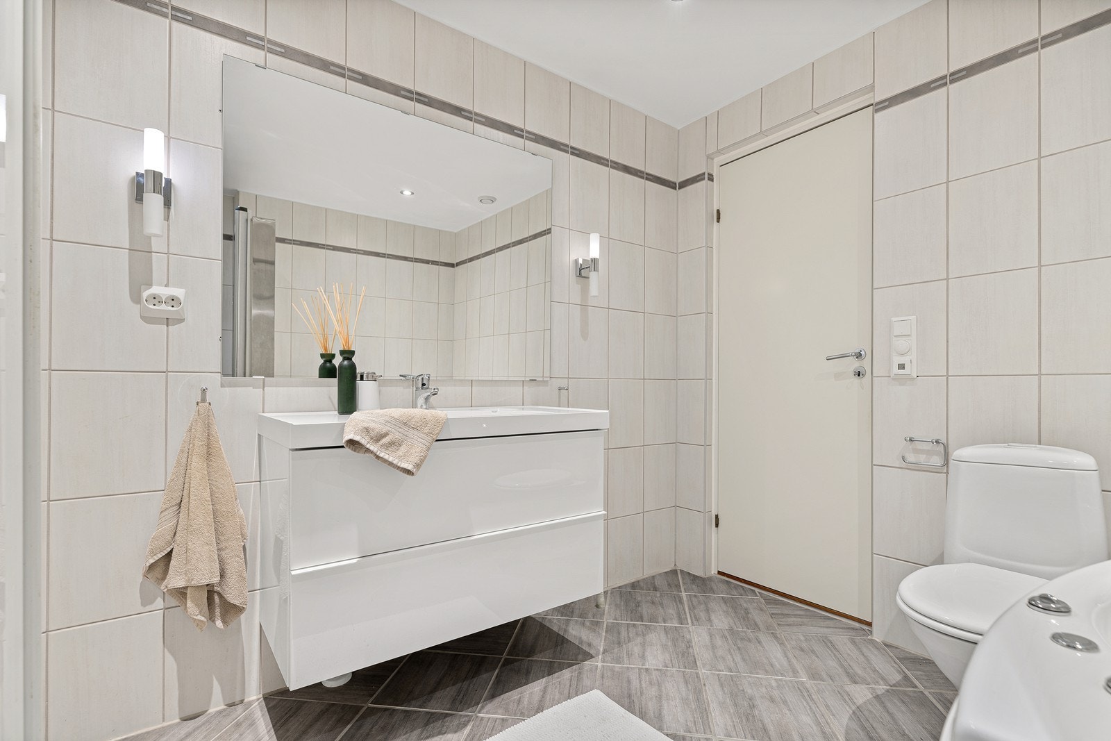 Badet er innredet med toalett, badekar, dusjhjørne og nedfelt servant Galleribilde