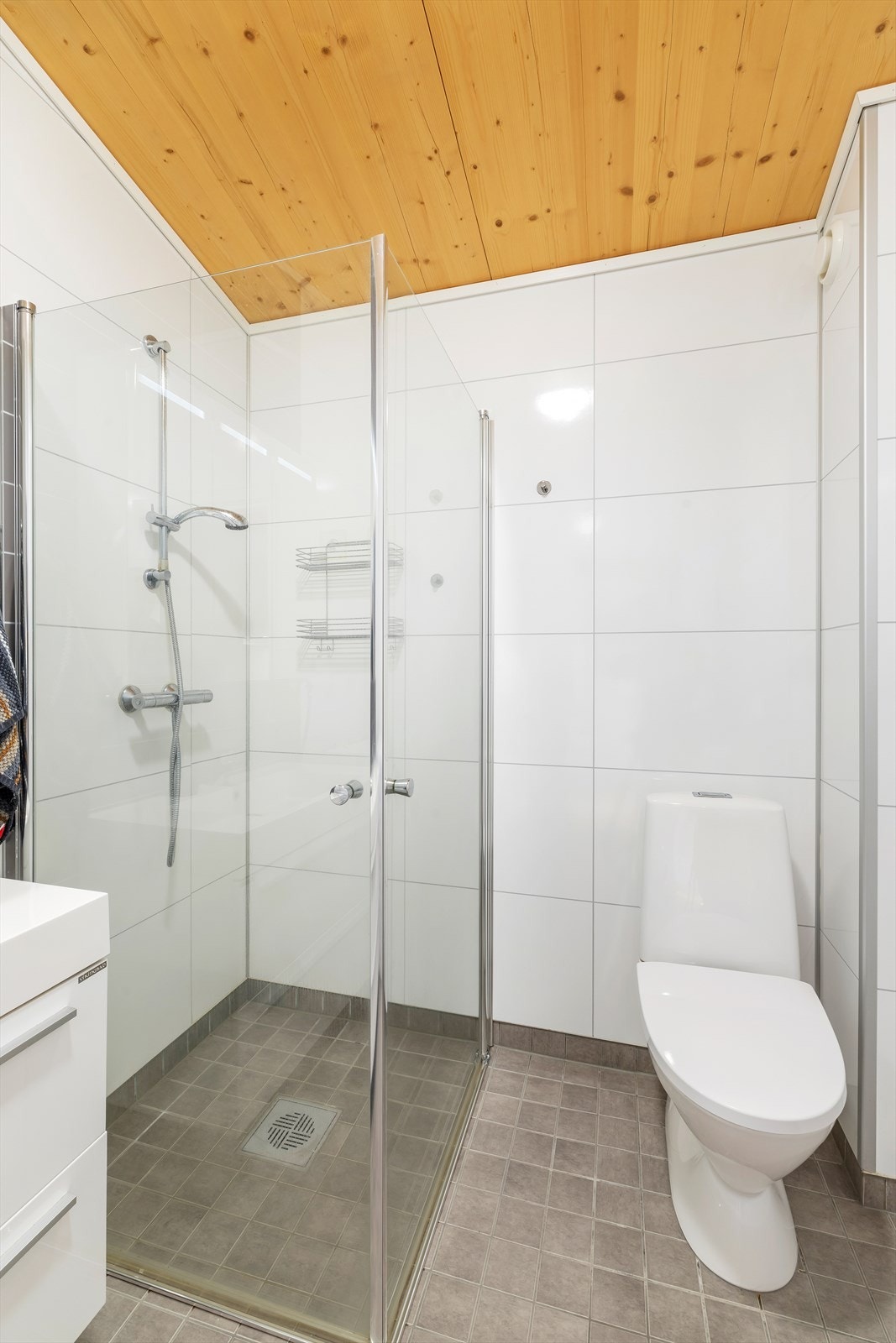 Flislagt gulv, våtromsplater på vegger og massivtre i himling. Galleribilde