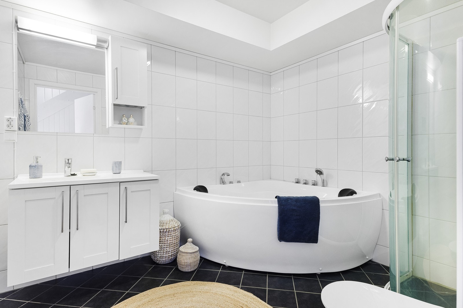 Bad med badekar, dusj, toalett og baderomsinnredning. Galleribilde